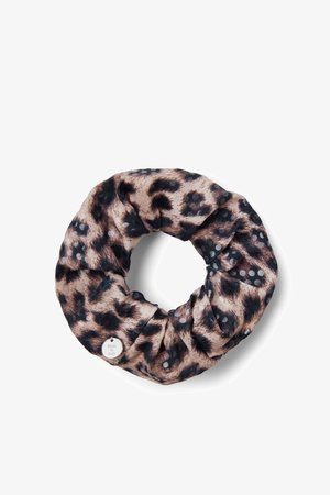 Chouchou en tissu imprimé léopard avec des taches noires et beiges et petits points argentés, avec une étiquette métallique ronde portant l’inscription "Made in Italy."