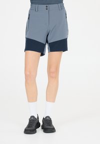 Grå och marinblå shorts med elastiskt midjeband, dragkedjefickor och en funktionell design. Tillsammans med svarta träningsskor och vita strumpor.