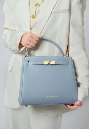 Borsa a mano strutturata azzurro chiaro in pelle testurizzata. Presenta dettagli in metallo dorato e un manico sottile. Logo dorato nell'angolo in basso a destra.