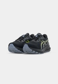 Zwarte sportieve schoenen met een bovenwerk van mesh, voorzien van grijze en neongele strepen, met een structuur rubberen zool en een versterkte neus.