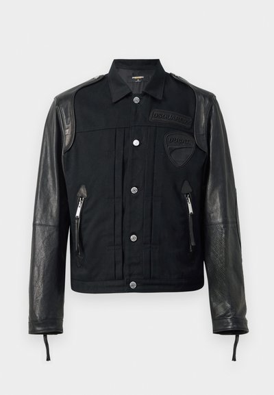 Giacca nera con una combinazione di tessuto e pelle. Presenta un colletto a punta, chiusure a bottone, tasche con zip e toppe con logo sul petto.