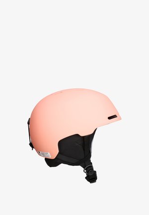 Peach-colored ski helmet with a matte finish, detachable black chin strap, and ventilation slots on top for airflow. CE certified label visible.