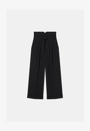 Schwarze weit geschnittene Hose mit hoher Taille, Bundfalten und einem Stoffgürtel. Die Bündchen sind hochgerollt, und es gibt einen dezenten Rückenausschnitt.
