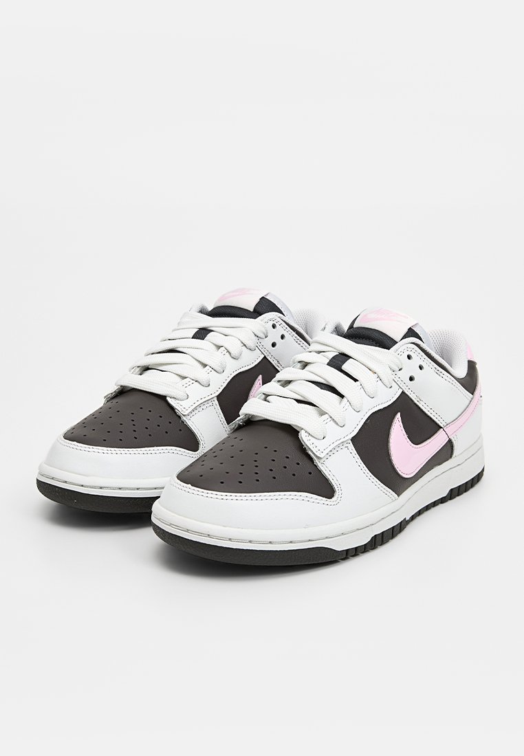 Weiße und braune Leder-Sneaker mit rosa Akzenten, durchlöchtem Zehenbereich, flachen Schnürsenkeln und Gummisohle. Mit Nike-Logo an der Seite.