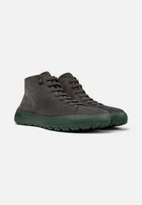Scarpe mid-top in pelle grigia scura, caratterizzate da una superficie texturizzata, suola in gomma verde e design con lacci a sei fori.