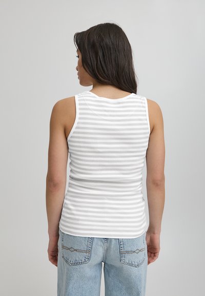 Biały top na ramiączkach z cienkimi szarymi paskami, teksturowana tkanina, okrągły dekolt i dopasowany krój, zestawiony z niebieskimi dżinsami z wysokim stanem.
