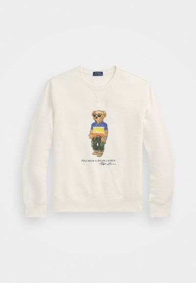 Cream-colored sweatshirt featuring a graphic of a bear in sunglasses, wearing a blue and yellow shirt with green pants, and text below.