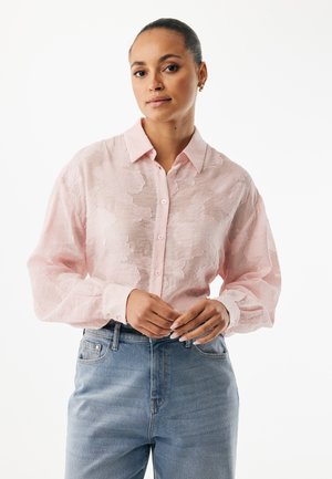 Lyserød skjorte med knapper, tekstureret blomsterprint, lange ærmer og klassisk krave, kombineret med højtaljede blå jeans.