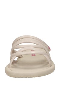 Beige platt sandal med tre tunna horisontella remmar och texturerad sula, visad i framvy mot vit bakgrund.
