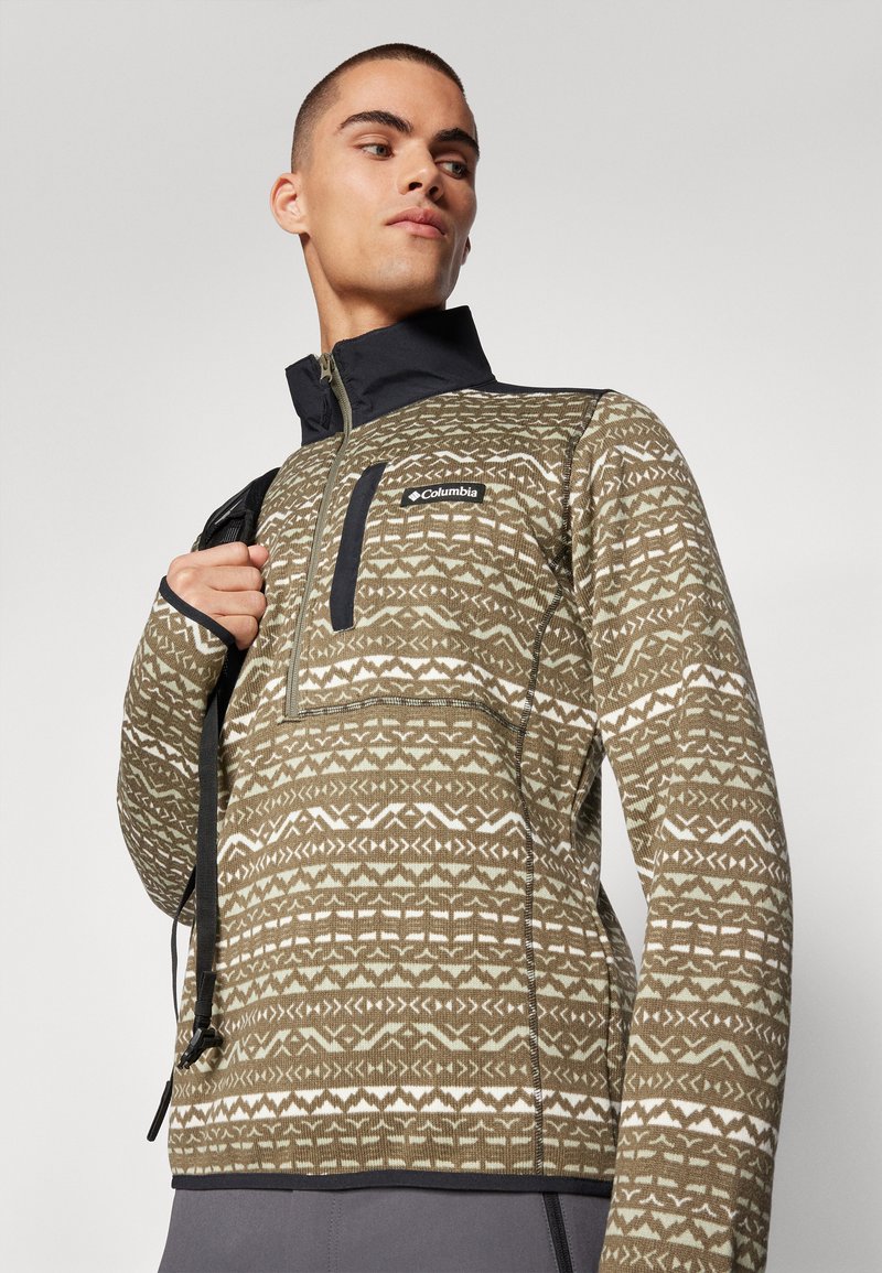 Sudadera Columbia, verde oliva con patrones geométricos, cuello con media cremallera, acentos en negro, fabricada en tejido texturizado, con bolsillo lateral con cremallera.