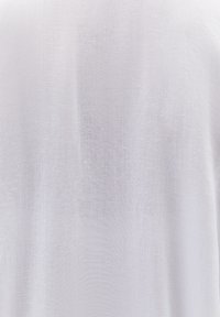 Tessuto in lino bianco con una superficie leggermente strutturata, che presenta un aspetto leggero e arioso, adatto per abbigliamento o tessuti per la casa.