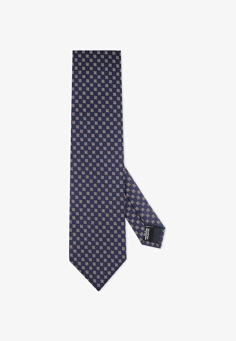 Granatowy krawat z małym białym geometrycznym wzorem kwiatowym, pokazany na płasko z widoczną metką na węższym końcu.
