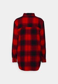 Chemise en flanelle à carreaux rouge et noir, poignets boutonnés, manches longues, détail en yoke au dos, texture douce, coupe décontractée, ourlet incurvé.