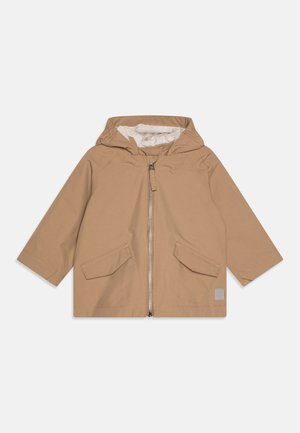 Børnestørrelse beige hættejakke med lynlås foran og to klaplommer på ensfarvet baggrund.