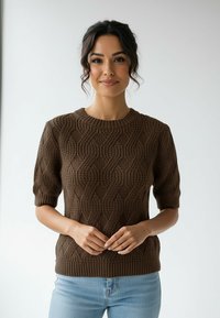 Brązowy sweter na drutach z fakturowanym wzorem fal, krótkimi rękawami i prążkowanym dekoltem, zestawiony z jasnoniebieskimi dżinsami.