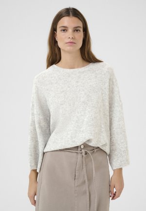 Lichtgrijze gebreide trui met een ronde halslijn en lange, losse mouwen, gecombineerd met een taupe rok met een strik taille en zijknopen.