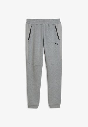 Szare zwężane spodnie dresowe z elastycznym pasem, kieszeniami na suwak po bokach, siateczkowymi panelami bocznymi oraz małym czarnym logo Puma na lewej udzie.