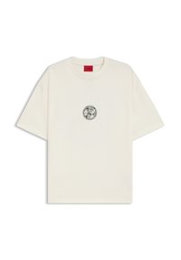 Cremefarvet kortærmet t-shirt lavet af bomuld, med et rundt grafisk logo i sort i midten og et rødt mærke på kraven.