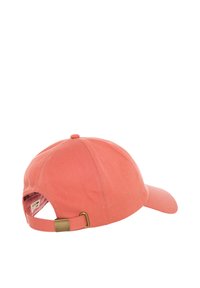 Adjustable cap in coral, made of cotton with a textured finish. Features a curved brim, embroidered eyelets, and a metal clasp for size adjustment.