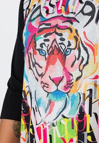 Grafische T-shirt met korte mouwen en een kleurrijk tijgermotief, met steentjesversieringen en een mix van gedurfde, gestileerde letters in levendige kleuren.
