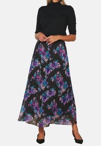 Maxi skirt in black fabric with a colorful floral pattern featuring purple and teal hues, flowy design, and pleated texture.