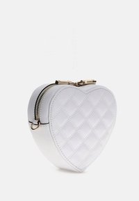 Hvid hjerteformet taske med quiltet mønster, guldfarvet hardware og dobbelte lynlåse. Glat tekstur med kompakt design.