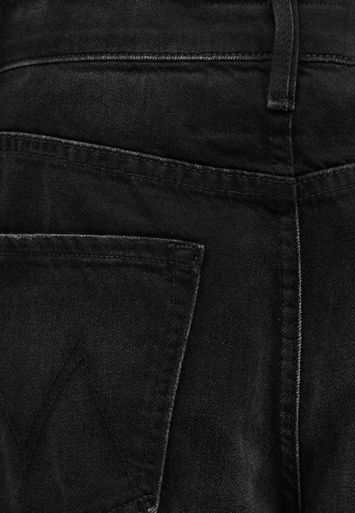 Μαύρο τζιν παντελόνι από υφή υφάσματος, με ορατές ραφές και πίσω τσέπη με τριγωνική σχεδιαστική λεπτομέρεια.