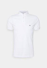 Polo shirt blanc à manches courtes en coton, avec un col classique, trois boutons et un petit logo coloré sur la poitrine gauche.