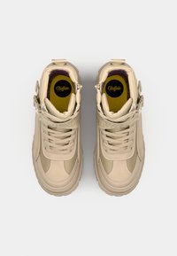 Beige hoge sneakers van gemengde materialen, met een textuur-overlay, vetersluiting en gesp-accenten. Gedrukte branding op de riem.