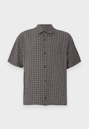 Πουκάμισο με κοντά μανίκια, κουμπιά, γιακά και τσέπη στο στήθος, ασπρόμαυρο καρό, σε απλό φόντο.