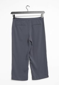 Grijze, high-waisted broeken van soepele stof. Heeft twee achterzakken met een subtiele naad. Hangt aan een zwarte hanger.