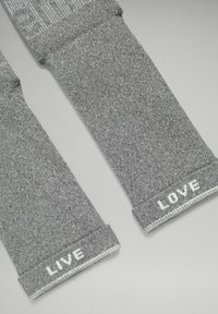 Szare wełniane skarpetki z prążkowanym mankietem, z białym napisem "LIVE" i "LOVE" na odpowiednich końcach. Teksturowana tkanina, prosty design.