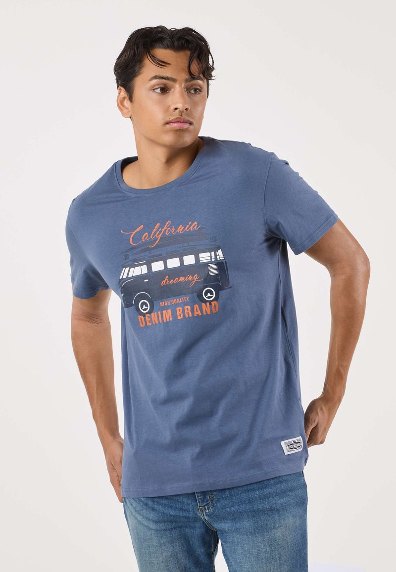 Blue cotton t-shirt featuring a graphic of a vintage van with "California dreaming" text in orange and black. Short sleeves, round neck design.