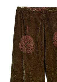 Brązowe aksamitne spodnie o luźnym kroju z dwoma bordowymi kwiatowymi nadrukami. Miękka tekstura, elastyczny pas i subtelny połysk.