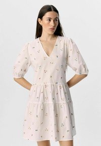Robe à manches courtes, décolleté en V en tissu rose clair, ornée de broderies florales colorées, d'un design en couches et de manches bouffantes froncées.