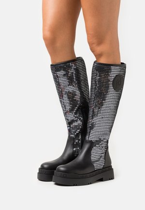 Zwart laarzen tot de knie met glanzende paillettenpanelen en stevige zwarte rubberen zolen. Voorzien van een rits en een reliëflogo-detail aan de zijkant.