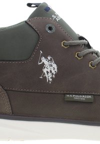 Bruna U.S. Polo Assn. sneaker med grön tygkrage, grå snören, vit sula och vit polo-spelare logotyp på sidan.