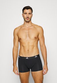 Svarta bomullsboxerbriefs med en åtsittande passform, som har en kontrasterande elastisk midjeband med ett vitt logomönster och sömdetaljer.