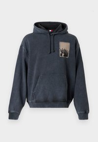 Hanorac gri închis cu un buzunar frontal, cu glugă cu șnur și un design grafic pătrat pe piept. Fabricat dintr-un material moale, periat.