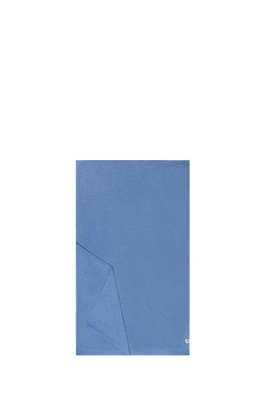 Blue rectangular cloth with a folded corner, plain texture, and a small white tag on the lower right edge.