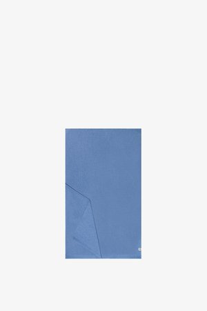 Blue rectangular cloth with a folded corner, plain texture, and a small white tag on the lower right edge.