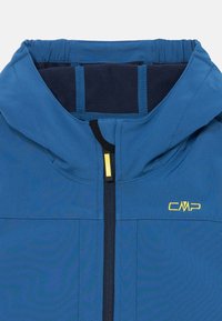 Veste bleue avec capuche. Elle présente une fermeture éclair à l'avant, une doublure en polaire douce près du cou et un logo jaune sur la poitrine.