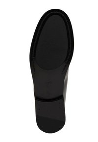 Czarna podeszwa buta o gładkiej fakturze, wyposażona w lekko podwyższony obcas, żebrowaną powierzchnię dla lepszej przyczepności oraz obszyty brzeg dla trwałości.