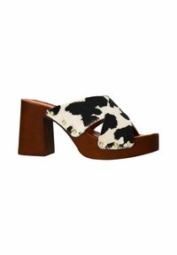 Chunky heeled sandal with brown leather base, featuring a black and white cowhide cross strap adorned with gold studs.