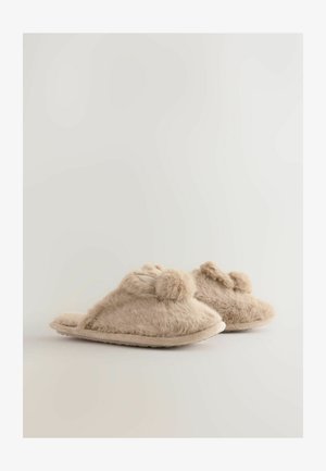 Bézs szőrös papucsok puha textúrával, nyitott orr designnal, pompom díszítéssel az elején és semleges színű talppal.