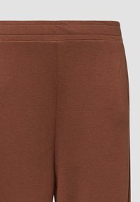 Pantalon de survêtement marron en mélange de coton doux avec une taille élastique et une texture lisse, présentant des coutures minimales et sans motifs ni accents.