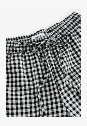 Kratke hlače s črno-belimi gingham vzorci, elastičnim pasom in vezalko. Tkanina se zdi lahka in ima mehak tekstur.
