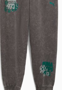 Grå, tapered sweatpants lavet af blødt materiale. Har grønne blomster grafikker og logoer, med ribbede cuffs ved anklerne.