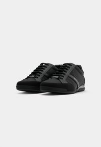 Zwarte sneakers met een gemengd materiaalontwerp, featuring gladde stof en suede accenten. Vetersluiting, gewatteerde zool en logo-detail.