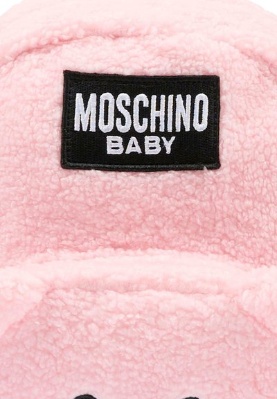 Miękka różowa polarowa tkanina z czarną prostokątną metką haftowaną z napisem "MOSCHINO BABY" białymi literami.